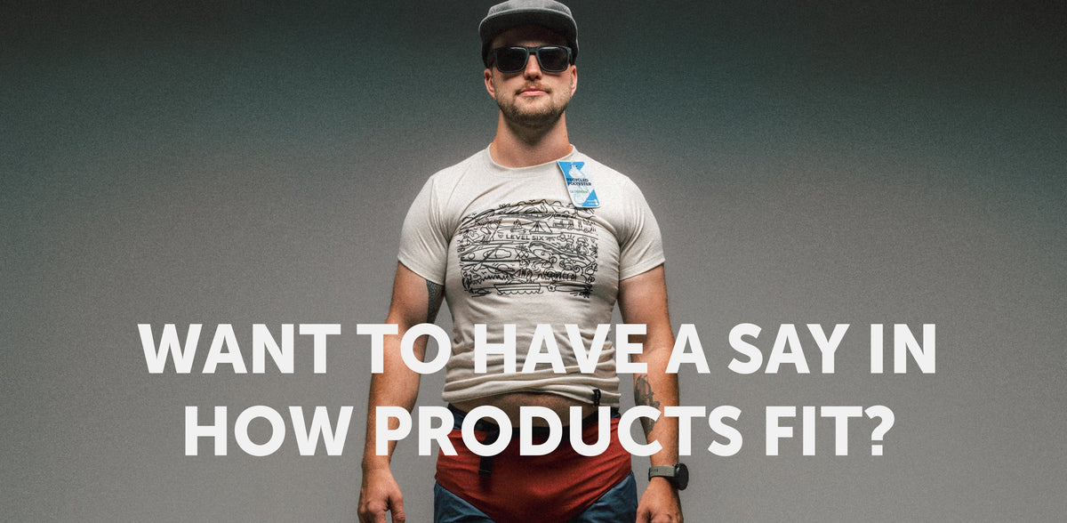 A paddler standing against a grey wall in a Level Six recycled polyester tee, with the words: Want to have a say in how products fit?